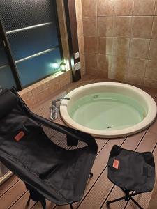 una bolsa negra sentada junto a una bañera en un baño en ROOM龍ヶ崎 -Adult only-, en Ushiku