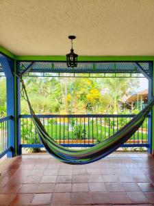 a hammock in a screened in porch with a view of a garden at La Casita del Sendero in Calarcá