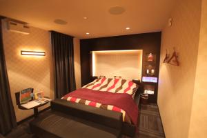 a bedroom with a bed and a desk in it at ROOM龍ヶ崎 -Adult only- in Ushiku