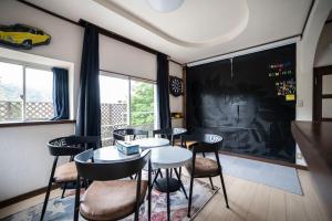 a room with a table and chairs and a chalkboard at 【芦ノ湖徒歩10分＆バス停1分】一棟貸切最大14人 大人數BBQ可能 パーティ 『ROUTE99』 in Moto-hakone