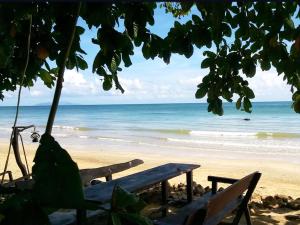 a bench on a beach with a view of the ocean at Room in Bungalow - Foresta Cottage of Koh Pu in Ko Jum