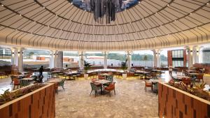 um restaurante com mesas e cadeiras e um tecto grande em Hotel Santika Premiere Linggarjati - Kuningan em Kuningan