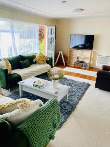 a living room with a couch and a table at Rosedale Retreat in Invercargill