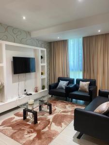 sala de estar con 2 sofás y TV de pantalla plana en Elegant 3 Bedroom Space Available en Accra