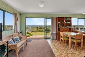 a living room with a table and chairs and a view at The Mermaid's Rest - Whatuwhiwhi Holiday Home in Kaitaia