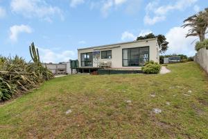 a house with a large yard in front of it at The Mermaid's Rest - Whatuwhiwhi Holiday Home in Kaitaia