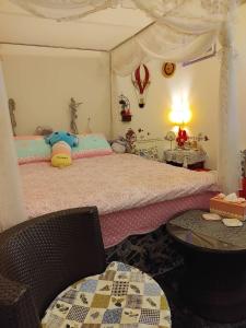 ein Schlafzimmer mit einem großen Bett und einem Tisch in der Unterkunft Pulisen Homestay in Puli