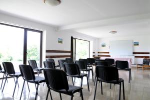a room with rows of chairs and a whiteboard at Pensiunea Recanto in Fundata
