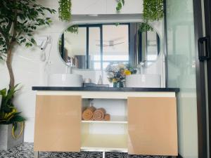 a bathroom vanity with a sink and a mirror at ND Happy House 1- CH sân vườn, CH chuẩn khách sạn tại số 10 ngách 5 ngõ 56 Hoa Lâm, Hà Nội in Hanoi
