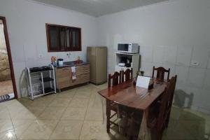 a kitchen with a wooden table and a refrigerator at Piatã Chapada Diamantina (Casa da Mãe) in Piatã