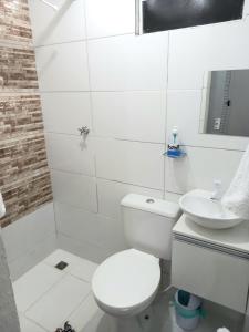 a white bathroom with a toilet and a sink at Apartamento Vila Telebrasilia in Brasília
