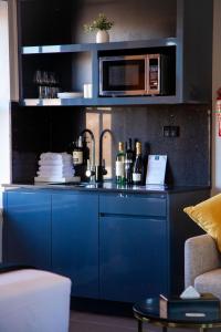 a blue kitchen with a sink and a microwave at Bayswater Boutique Lodge in Sydney