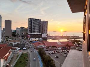 a city skyline with cars parked in a parking lot at J' Stay Jesselton Quay City Centre 邻近码头 in Kota Kinabalu