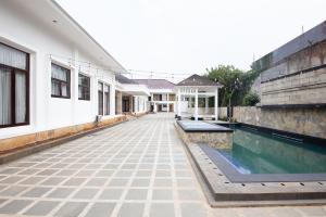 een lege binnenplaats van een huis met een zwembad bij RedDoorz Premium @ Gandaria Jagakarsa in Jakarta