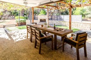 a wooden table and chairs in a patio with a fireplace at Barn Haus in Margaret River Town +16 photos