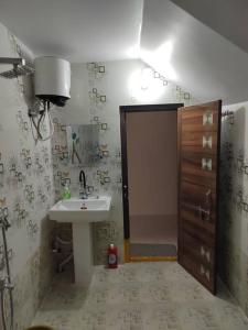 uma casa de banho com um lavatório, um chuveiro e uma porta em Gangi Kota North Flat em Kovvūr