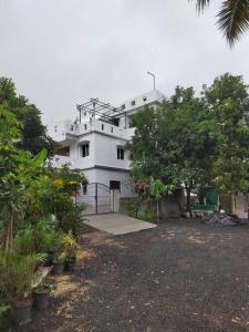 a large white building with trees in front of it at Gangi Kota North Flat in Kovvūr