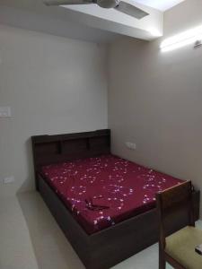 uma cama num quarto com um cobertor vermelho em Gangi Kota North Flat em Kovvūr
