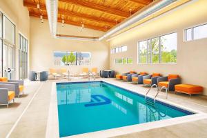 ビーチウッドにあるAloft Beachwoodの椅子とテーブル付きの客室内のプールを利用できます。