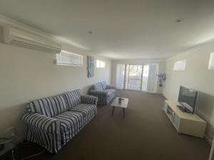 a living room with two couches and a tv at Unit 54 Seafront Estate in Jurien Bay