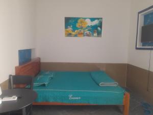 Cette petite chambre comprend un petit lit et une table. dans l'établissement Ha Na Đức Linh, 