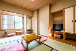een woonkamer met een tafel en een televisie bij Ooedo Onsen Monogatari Masuya in Osaki