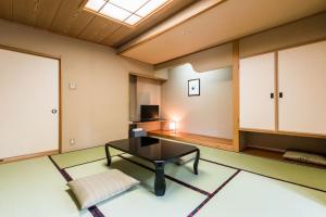 sala de estar con mesa y TV en Ooedo Onsen Monogatari Masuya, en Osaki