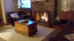 a living room with a fireplace and a tv at Book Keepers Cottage in Waikerie