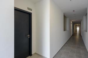 un corridoio con porta nera e pareti bianche di MyRehat Lestari @ Neu Suites a Kuala Lumpur