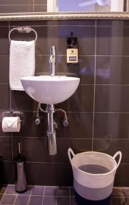 uma casa de banho com um lavatório e uma cesta em Bayswater Boutique Lodge em Sydney