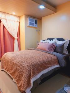 a bedroom with a large bed and a window at Congressional Town Center in Manila