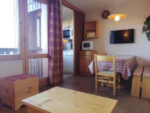 een kleine kamer met een tafel en een keuken bij Appartement Valmorel, 2 pièces, 5 personnes - FR-1-356-190 in Valmorel