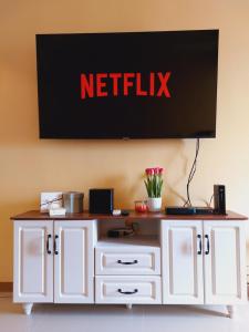 a white cabinet with a netflix sign on the wall at Congressional Town Center in Manila