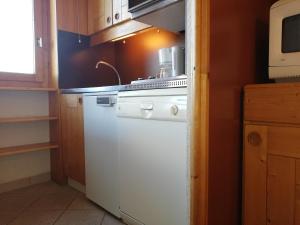 cocina con fogones blancos y microondas en Appartement Valmorel, 2 pièces, 5 personnes - FR-1-356-190, en Valmorel