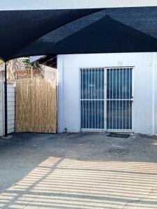 uma garagem branca com um portão e uma cerca em Annies Overnight em Vanderbijlpark