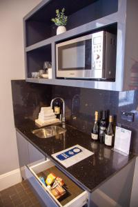 a kitchen with a sink and a microwave at Bayswater Boutique Lodge in Sydney