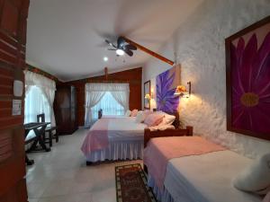 a bedroom with two beds and a ceiling fan at Villa Luzandi in Quimbaya