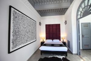 a bedroom with a bed and a large picture on the wall at Riad7 in Azemmour