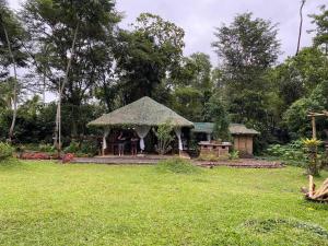 einen Pavillon in einem Garten mit einem Rasenplatz in der Unterkunft CROSSROADS HAVEN FARM in Majayjay