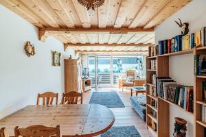een woonkamer met een houten tafel en boekenplanken bij Ferienwohnung Michael - ruhig gelegen und nah am See in Schliersee