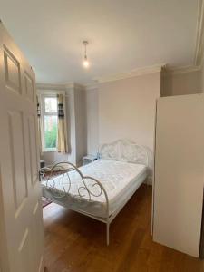 a small bedroom with a bed and a refrigerator at Delightful Victorian House in Manchester