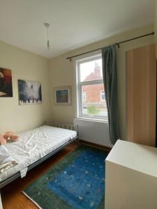 a bedroom with a bed and a large window at Delightful Victorian House in Manchester
