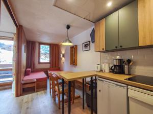 a kitchen with a table and chairs in a room at Appartement Valmorel, 1 pièce, 4 personnes - FR-1-356-257 in Valmorel