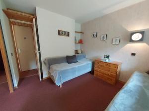 a bedroom with a bed and a dresser and a door at Appartement Valmorel, 1 pièce, 4 personnes - FR-1-356-258 in Valmorel