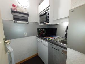 a small kitchen with white cabinets and a sink at Appartement Valmorel, 1 pièce, 4 personnes - FR-1-356-258 in Valmorel