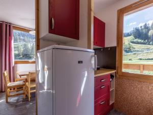 a kitchen with a refrigerator and a table and a window at Appartement Valmorel, 2 pièces, 4 personnes - FR-1-356-301 in Valmorel