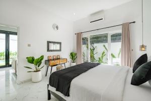 Un dormitorio blanco con una cama y un escritorio. en Villa Marina Seminyak, en Seminyak 22 fotos más