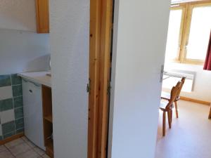 a kitchen with a table and a chair in a room at Appartement Valmorel, 1 pièce, 4 personnes - FR-1-356-350 in Valmorel