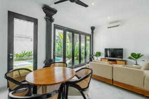 a living room with a table and chairs and a couch at Villa Marina Seminyak in Seminyak