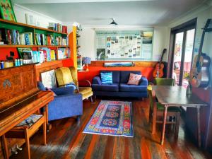 a living room with a couch and a piano at Bellingen Belfry Guesthouse in Bellingen